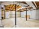 Unfinished basement with concrete floor, exposed ceiling, black support beams, and white door awaiting customization at 345 Sharon Dr, Fayetteville, GA 30214