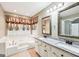 Bathroom with double sink vanity, granite countertop, soaking tub, and decorative mirrors at 345 Sharon Dr, Fayetteville, GA 30214