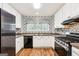 Well-lit kitchen featuring stainless steel appliances, black accents and stylish wallpaper at 345 Sharon Dr, Fayetteville, GA 30214