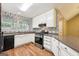 Well-lit kitchen featuring white cabinets, stainless steel appliances, and stylish patterned wallpaper at 345 Sharon Dr, Fayetteville, GA 30214