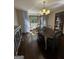 Inviting dining room with hardwood floors, a chandelier and a view of the trees outside the window at 3970 Governors Cir, Loganville, GA 30052