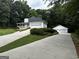 Inviting home with a two-car garage, a long driveway, and nestled amongst lush greenery at 3970 Governors Cir, Loganville, GA 30052