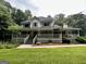 Charming two-story home with a large wraparound porch and a lush green lawn at 3970 Governors Cir, Loganville, GA 30052