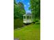 Picturesque gazebo on a grassy lawn next to a tranquil lake, surrounded by lush green trees and blue sky at 3970 Governors Cir, Loganville, GA 30052
