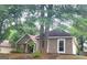 Single Gathering house featuring a stone accent wall, stucco siding, an attached garage, mature trees, and landscaping at 455 Old Ivy Path, Mcdonough, GA 30253