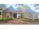 Charming single Gathering home with stone accents, neutral stucco exterior, mature landscaping, and a covered front porch entry at 455 Old Ivy Path, Mcdonough, GA 30253