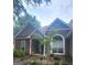Well maintained house with a stone accent wall, arched window, covered entryway, and tidy landscaping under a beautiful sky at 455 Old Ivy Path, Mcdonough, GA 30253