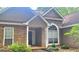 Charming home featuring a stone facade, stucco accents, a covered porch, and arched window, surrounded by established landscaping at 455 Old Ivy Path, Mcdonough, GA 30253