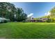 Expansive backyard with lush green grass, mature trees, and a covered patio for outdoor entertaining at 8815 Campbellton St, Douglasville, GA 30134