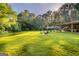 Lush backyard with towering trees offering ample shade, a charming patio area, and plenty of space for recreation at 8815 Campbellton St, Douglasville, GA 30134