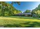 Sprawling yard featuring the side of the brick house, with trees in the background at 8815 Campbellton St, Douglasville, GA 30134