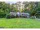 Charming brick home with a well-manicured lawn and mature trees, offering a serene and inviting curb appeal at 8815 Campbellton St, Douglasville, GA 30134
