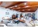 Spacious living area featuring wood-beamed ceilings, a piano, and an open layout leading to a modern kitchen at 8815 Campbellton St, Douglasville, GA 30134
