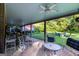 Covered brick patio featuring comfortable seating, ceiling fans, and a relaxing view of the lush green backyard at 8815 Campbellton St, Douglasville, GA 30134