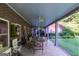 Covered brick patio offering ample seating with views of the expansive backyard and mature landscaping at 8815 Campbellton St, Douglasville, GA 30134