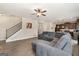 Open-concept living room with hardwood floors, ceiling fan, and a staircase leading to the upper level at 2277 Church St, Hampton, GA 30228