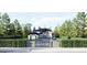 A luxurious, two-story home is surrounded by luscious green trees with a driveway leading to the front gate at 3181 Buck Branch Rd, Conyers, GA 30094