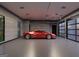 A luxury garage features a large, red sports car parked in the center on a speckled floor and modern fixtures at 3181 Buck Branch Rd, Conyers, GA 30094