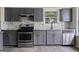 Modern kitchen featuring gray cabinets, stainless steel appliances, and a tiled backsplash at 5368 Nw Stafford Nw Dr, Lilburn, GA 30047