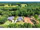 Expansive aerial view showcasing the home's location with wooded backdrop and neighboring land at 204 Pinehurst Way, Carrollton, GA 30116