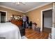 Comfortable bedroom with a dresser, hardwood floors, walk-in closet, and warm, inviting color scheme at 204 Pinehurst Way, Carrollton, GA 30116