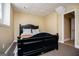 Well-lit bedroom with a dark bed frame and neutral colored walls at 204 Pinehurst Way, Carrollton, GA 30116