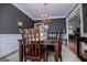 Elegant dining room with chandelier, dark wood table, and view to an adjacent room at 204 Pinehurst Way, Carrollton, GA 30116