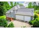 Aerial image showcasing the home's large garage and exterior with a beautiful treed backdrop at 204 Pinehurst Way, Carrollton, GA 30116