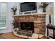 Stone fireplace with mantle, TV, and decorative accents in a well-lit room at 204 Pinehurst Way, Carrollton, GA 30116