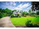 Spacious front yard with lush green lawn and charming two-story home surrounded by mature trees at 204 Pinehurst Way, Carrollton, GA 30116