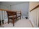 Hallway with a wooden bench and white railings leading to the upper level, creating a cozy and inviting transition space at 204 Pinehurst Way, Carrollton, GA 30116