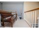 Hallway with a wooden bench and white railings leading to the upper level, creating a cozy and inviting transition space at 204 Pinehurst Way, Carrollton, GA 30116