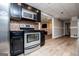 Well-equipped kitchen with stainless steel appliances, black cabinetry, and tiled backsplash at 204 Pinehurst Way, Carrollton, GA 30116