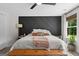 A well-lit bedroom features a textured black accent wall and a comfortable king-sized bed at 500 Happy Hollow Rd, Villa Rica, GA 30180
