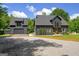 Beautiful modern farmhouse exterior with a detached garage and a gravel driveway surrounded by lush greenery at 500 Happy Hollow Rd, Villa Rica, GA 30180