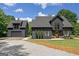 Contemporary home with dark siding, a matching detached garage, manicured lawn, and stone driveway for modern curb appeal at 500 Happy Hollow Rd, Villa Rica, GA 30180