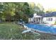 Lush backyard with trees, an in-ground pool, and partial view of house at 1858 Mcconnell Rd, Grayson, GA 30017