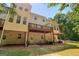 Spacious back exterior with a deck, ground floor patio, and lush greenery surrounds the property at 56 American Walk, Peachtree City, GA 30269
