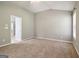 Neutral bedroom featuring a large window, plush carpeting, vaulted ceilings and door to bath at 56 American Walk, Peachtree City, GA 30269
