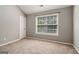 Neutral bedroom featuring a large window, plush carpeting, and a vaulted ceiling at 56 American Walk, Peachtree City, GA 30269