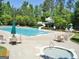 A well-maintained community pool featuring a slide, hot tub, lounge chairs, and umbrella-covered tables at 56 American Walk, Peachtree City, GA 30269