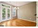 Sunlit dining room featuring hardwood floors, elegant chandelier, and access to outdoor space at 56 American Walk, Peachtree City, GA 30269