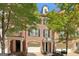 Charming brick townhouse with a one-car garage, black shutters, and mature trees at 56 American Walk, Peachtree City, GA 30269