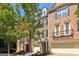 Attractive brick townhome with a one-car garage, small balcony, and a beautifully maintained front yard at 56 American Walk, Peachtree City, GA 30269