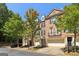Beautiful brick townhomes with attached garages, balconies, and mature trees along the street at 56 American Walk, Peachtree City, GA 30269