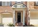Close-up of front door with brick archway, columns and one-car garage at 56 American Walk, Peachtree City, GA 30269