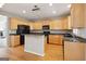 Well-appointed kitchen features natural wood cabinets, black appliances, and center island at 56 American Walk, Peachtree City, GA 30269