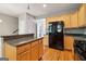 Kitchen featuring stainless steel appliances, custom cabinets, granite counters, and hardwood floors at 56 American Walk, Peachtree City, GA 30269