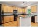 Modern kitchen showcasing wood cabinets, black appliances, and granite countertops at 56 American Walk, Peachtree City, GA 30269