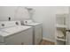 Laundry room featuring a washer, dryer and shelving unit for storage at 56 American Walk, Peachtree City, GA 30269